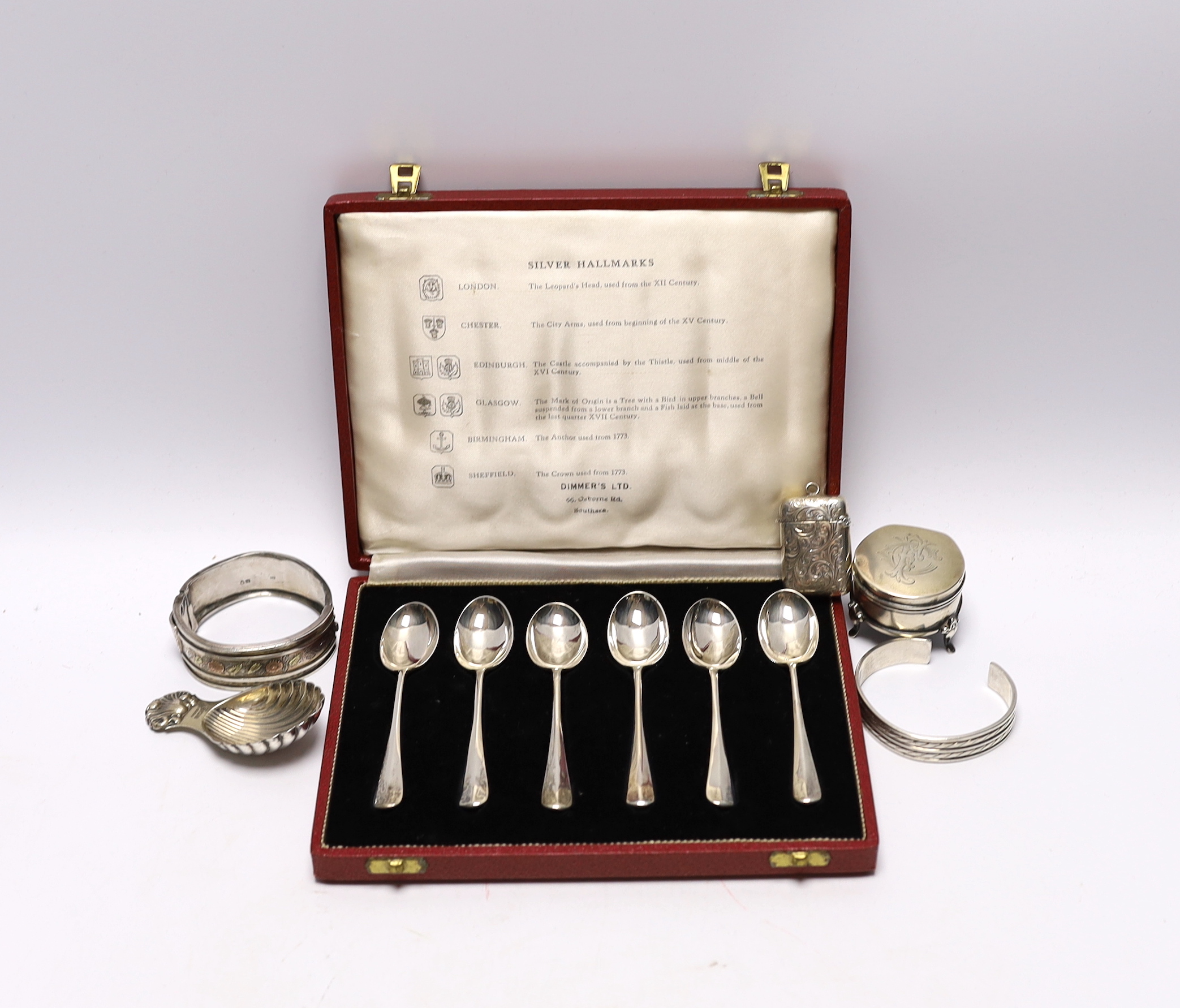 A modern silver caddy spoon, a small Edwardian silver mounted trinket box, a silver vesta case, a Victorian silver bangle and a 925 bangle and a cased set of six silver 'Hallmark' spoons.